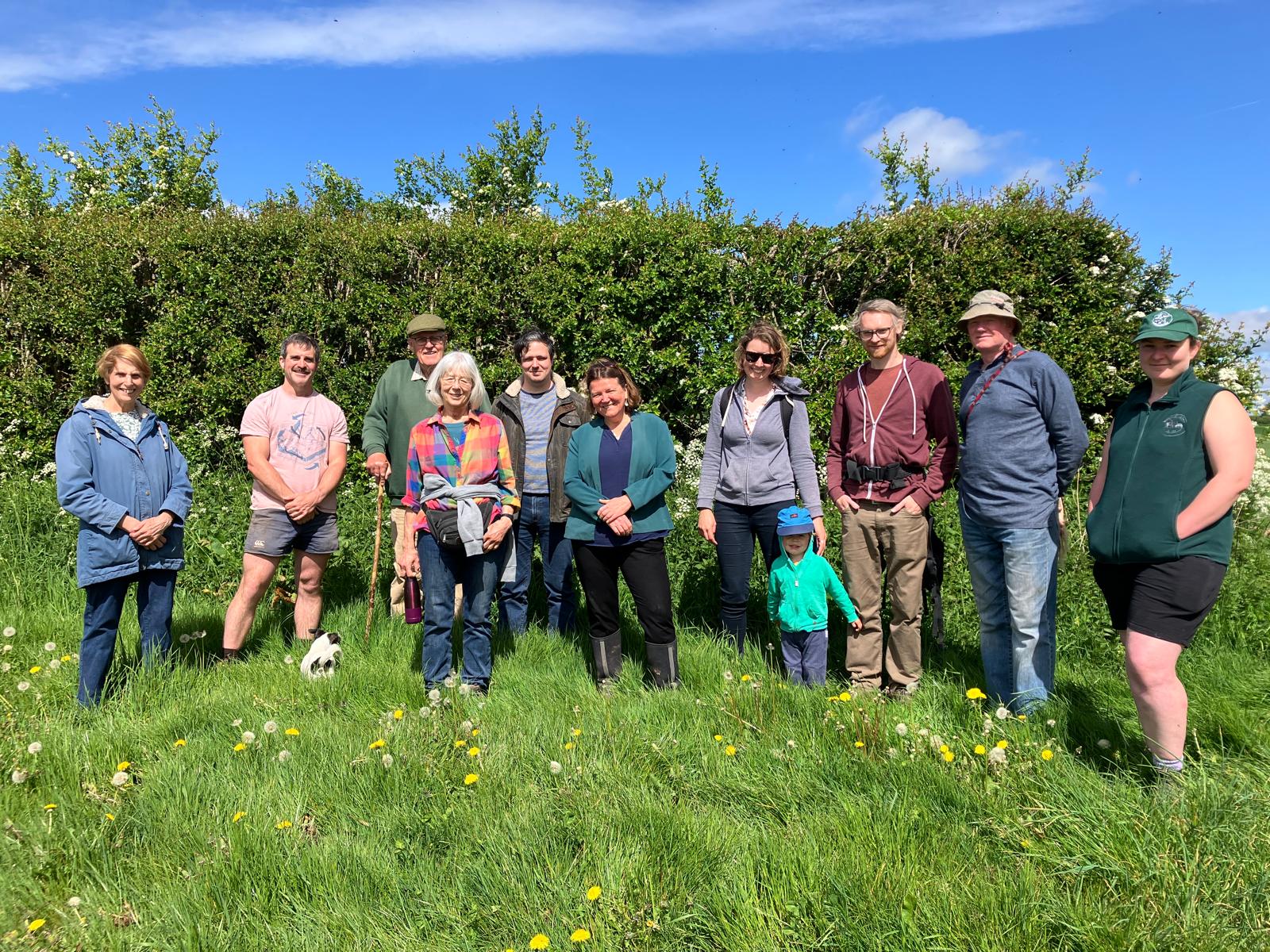 Ellie Chowns in a sunny meadow with farmers from Herefordshire.