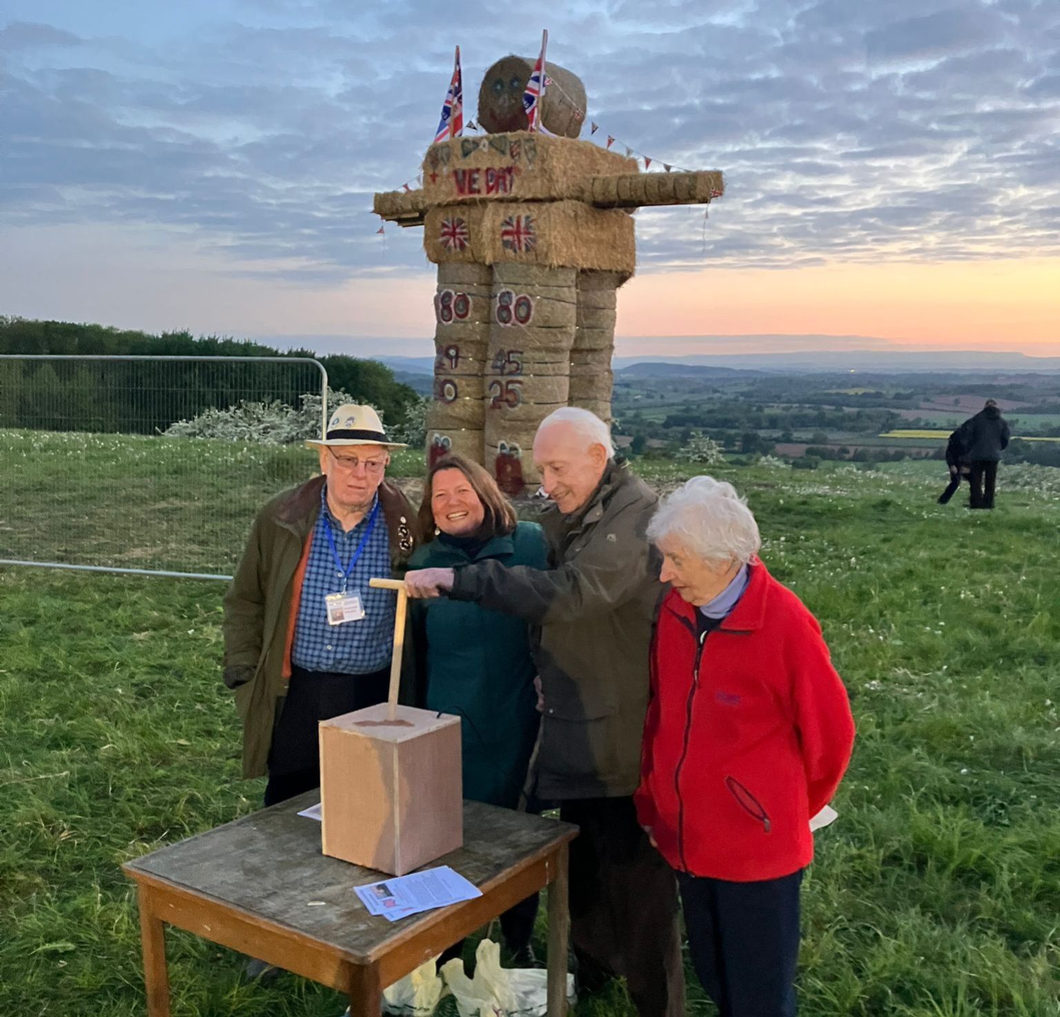 Hilltop with Ellie Chowns ready to light a straw man made of hay bales.